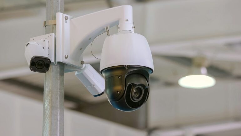 Rotating black surveillance control camera indoors.